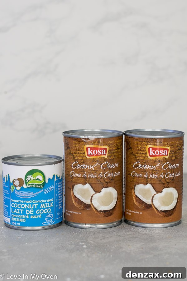 Overhead shot of cocoa powder being added to whipped coconut cream in a stand mixer bowl