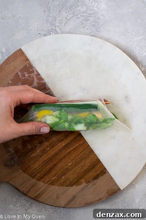 A perfectly rolled turkey pepperoni salad roll, showcasing the neat wrap and visible fillings, ready for serving.