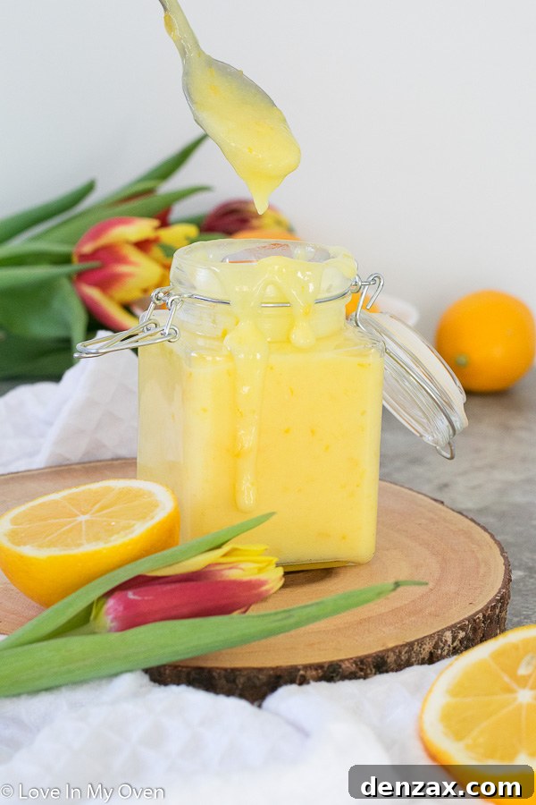 A bowl of Meyer lemon curd with fresh lemons and a whisk nearby.