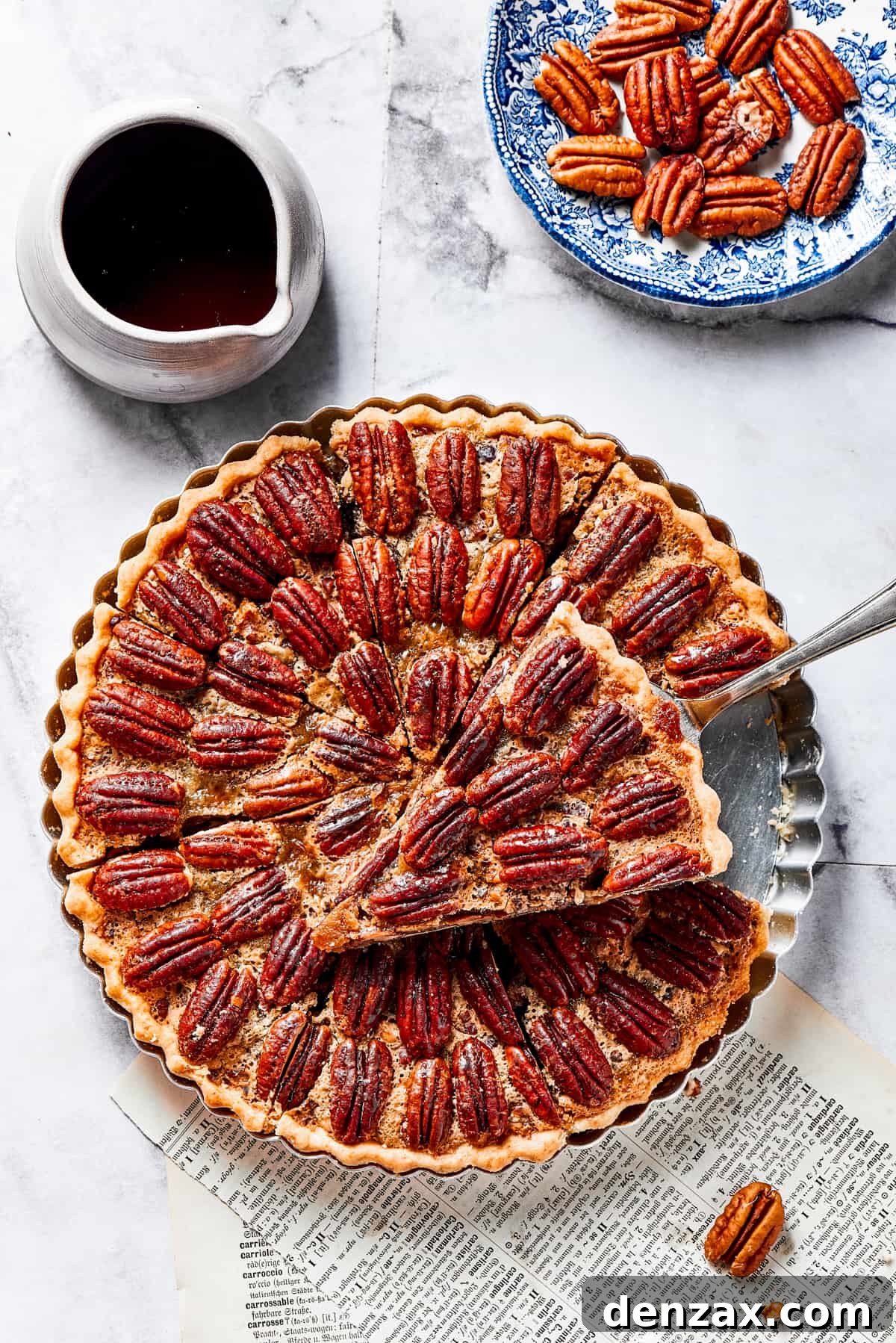 The Best Pecan Pie Recipe is here, easy to make and perfect for your holiday table! You'll love the homemade crust and sweet, nutty filling. A perfectly baked slice of pecan pie, lifted on a pie server, showcasing its rich, golden-brown crust and glistening, nutty filling.