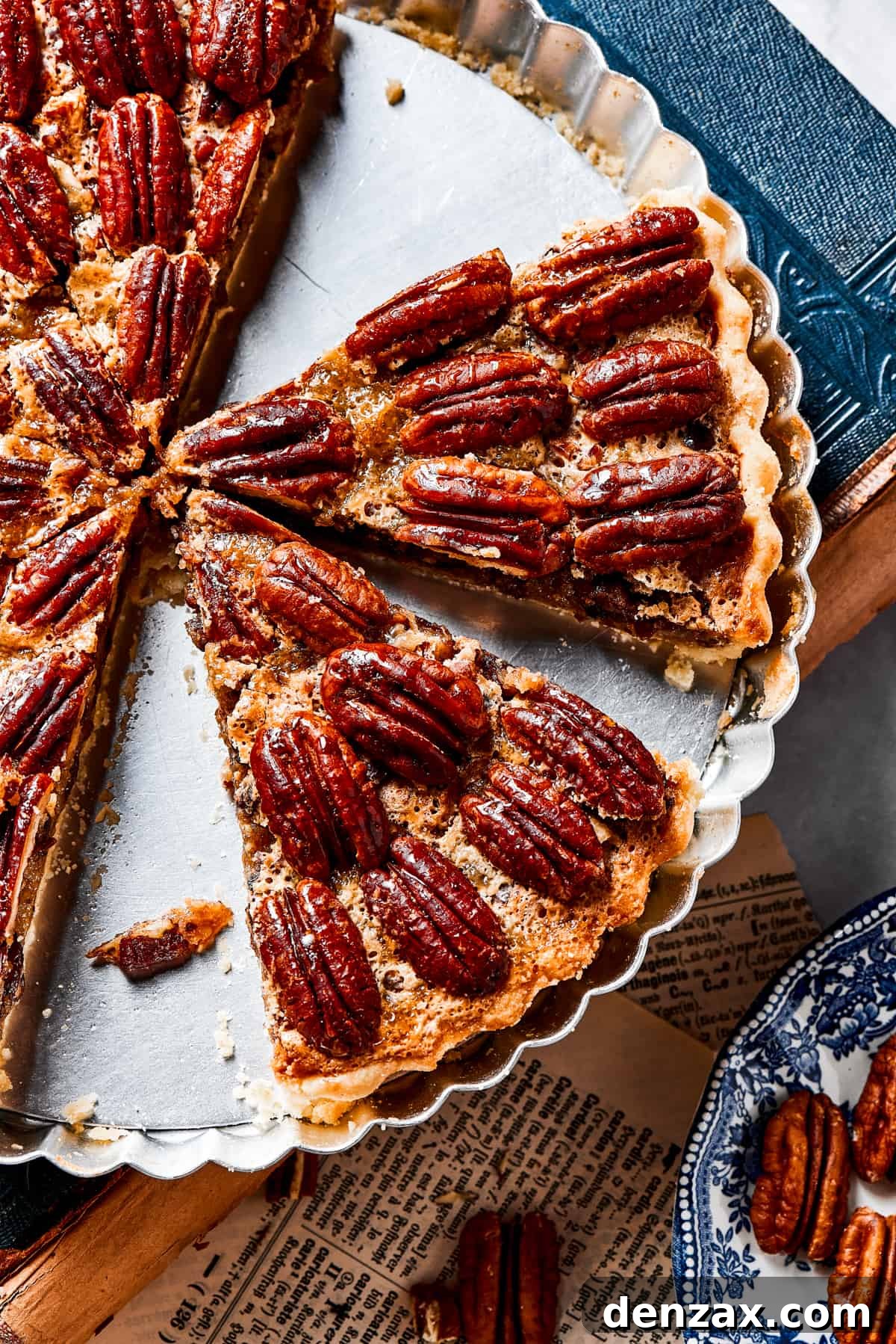 The Best Pecan Pie Recipe is here, easy to make and perfect for your holiday table! You'll love the homemade crust and sweet, nutty filling. A pie dish containing several slices of homemade pecan pie, ready to be enjoyed.