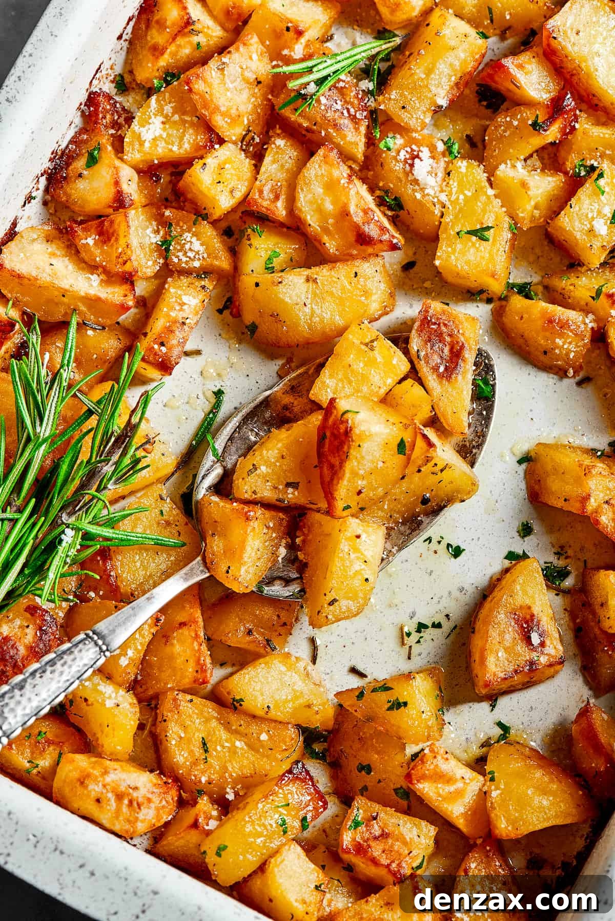 A baking dish with seasoned potatoes arranged inside, ready for the oven.