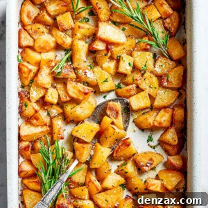 A large baking dish full of baked, seasoned potato pieces, golden and crispy.