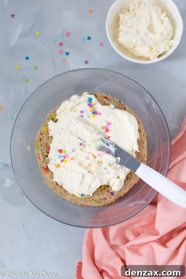 Finished healthy birthday cake, beautifully frosted with white chocolate cream cheese frosting and colorful sprinkles.