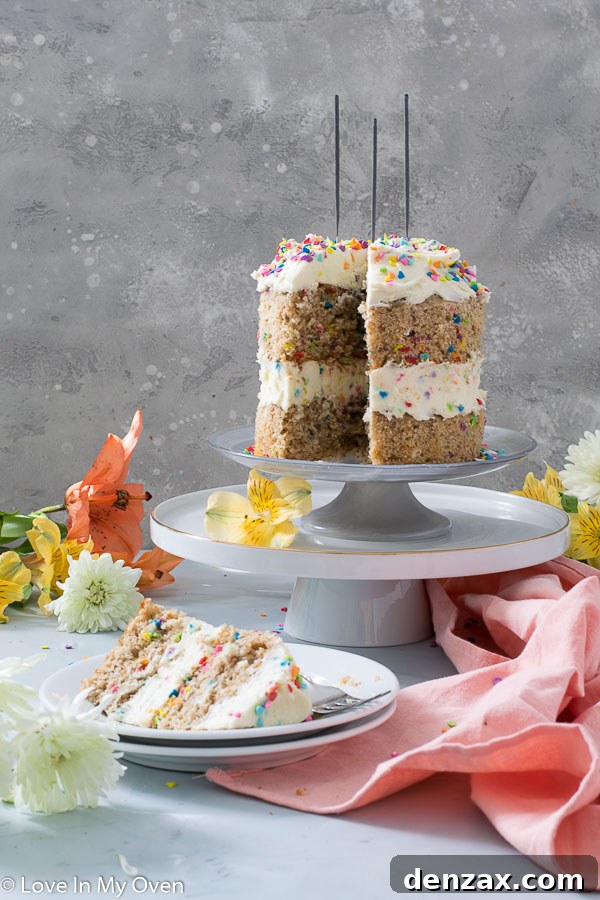 Two-tier healthy birthday cake on a cake stand, decorated with festive sprinkles and ready for celebration.