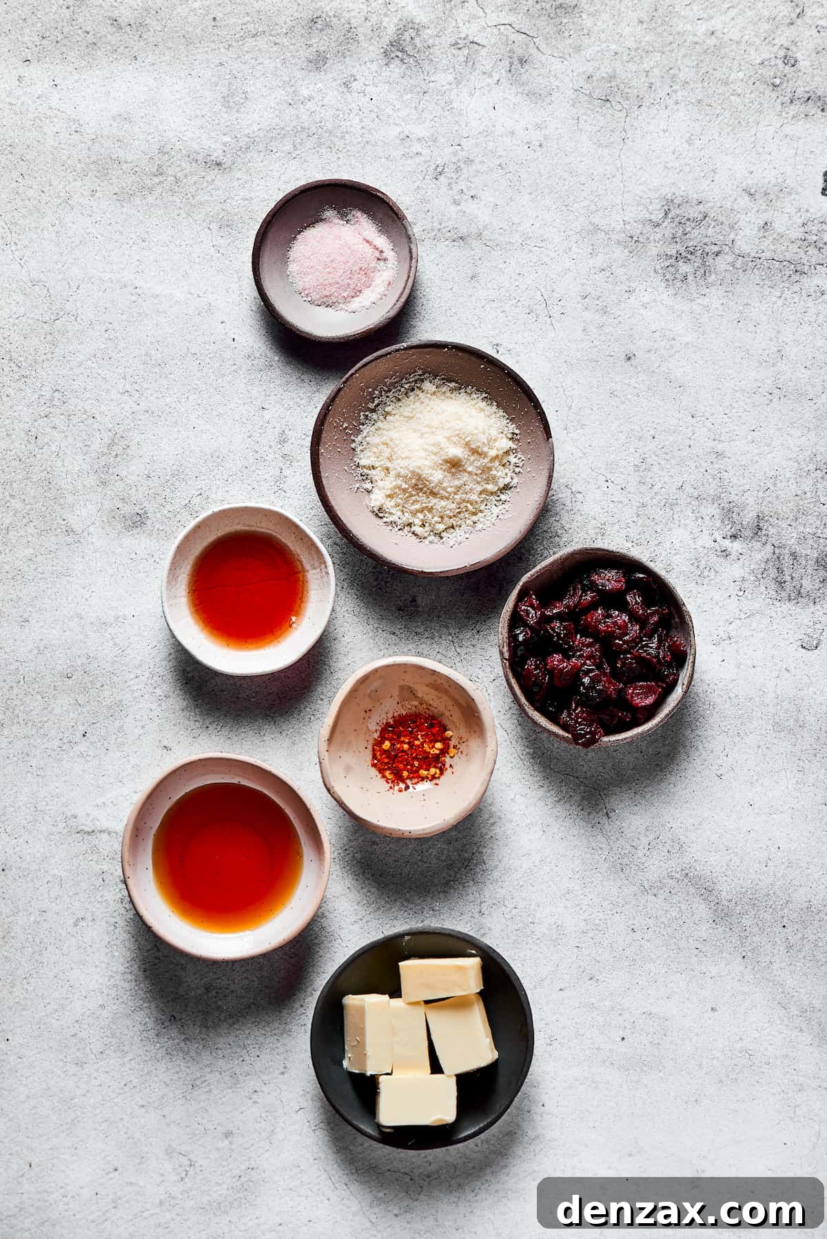 Ingredients for the glaze and garnish: Salt, Parmesan cheese, dried cranberries, red chili flakes, butter, maple syrup, and pomegranate vinegar.