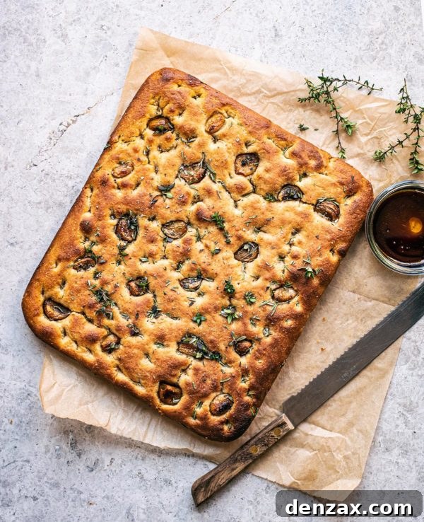Golden Sourdough Focaccia, drizzled with olive oil and topped with herbs.