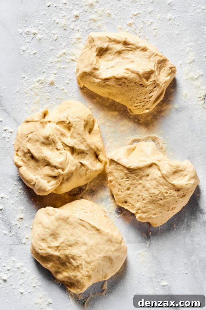 Dough portioned into 4 pieces on a floured work surface.