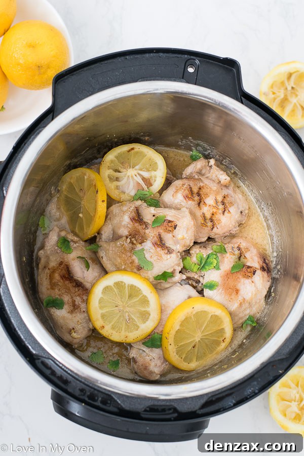 Instant Pot Lemon Garlic Chicken Thighs served on a plate with fresh herbs.