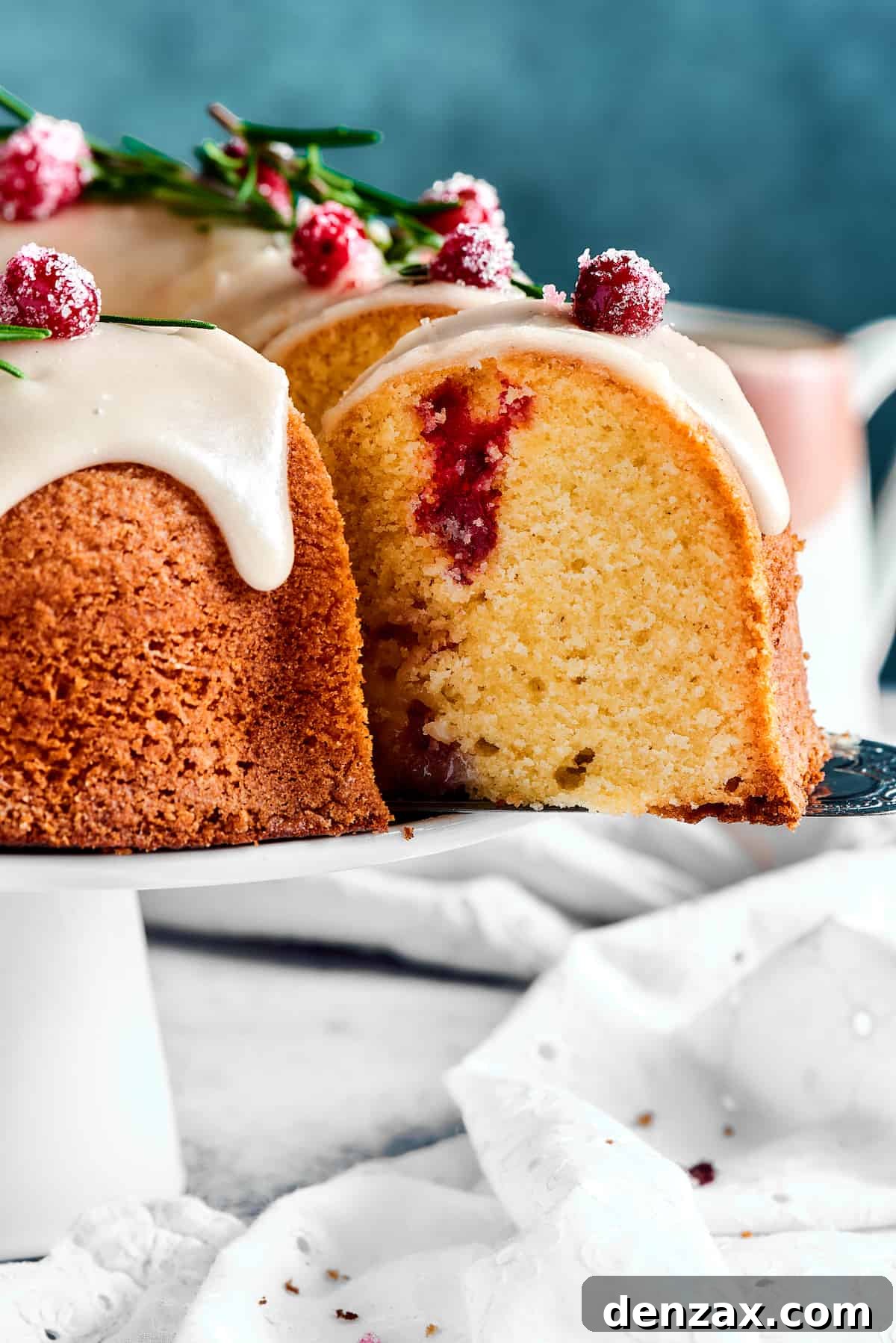 A hand picking up a perfect slice of Christmas Cranberry Pound Cake with a cake server, revealing the tender, moist interior.