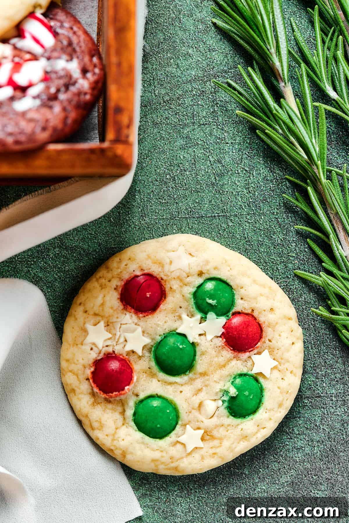 A beautifully decorated Christmas sugar cookie with white chocolate star candies and colorful M&M's, highlighting intricate holiday confectionery.