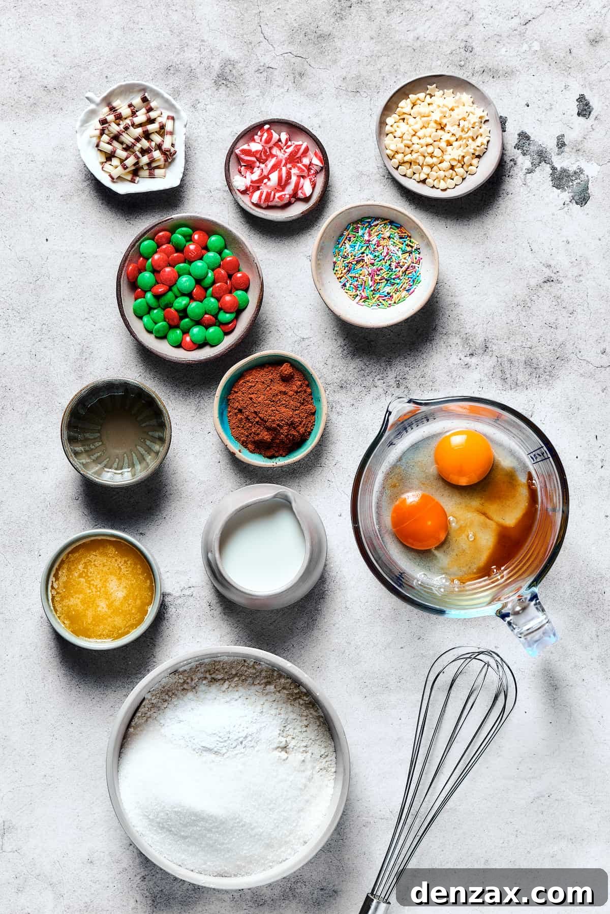 All the essential ingredients for making delicious cake mix cookies laid out neatly on a table, including cake mix, M&M's, butter, and eggs.