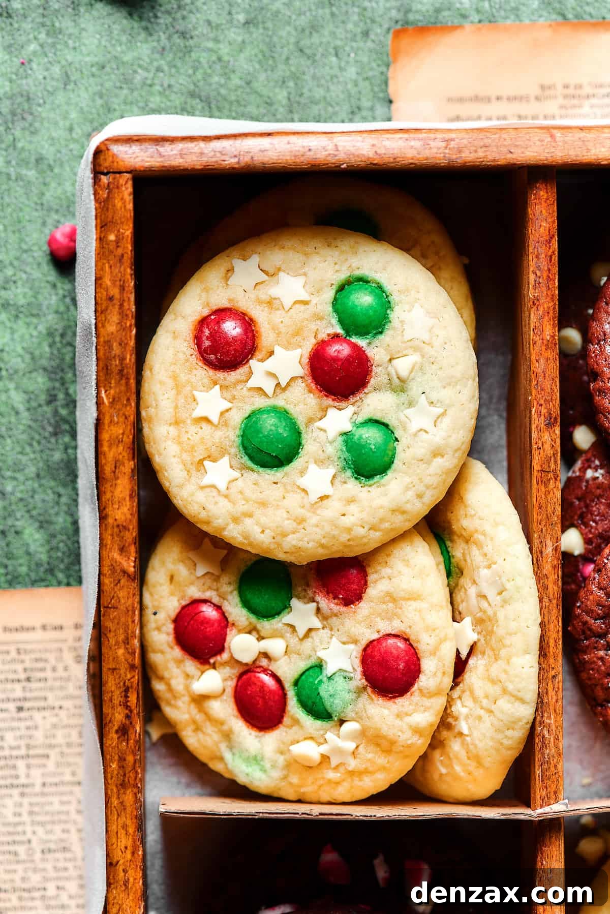 Beautifully baked sugar cookies featuring a mix of red and green M&M's and delicate white chocolate star sprinkles, ready for holiday festivities.