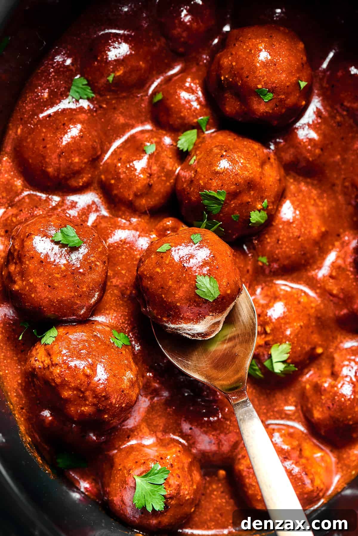 Meatballs in sauce, sprinkled with parsley.