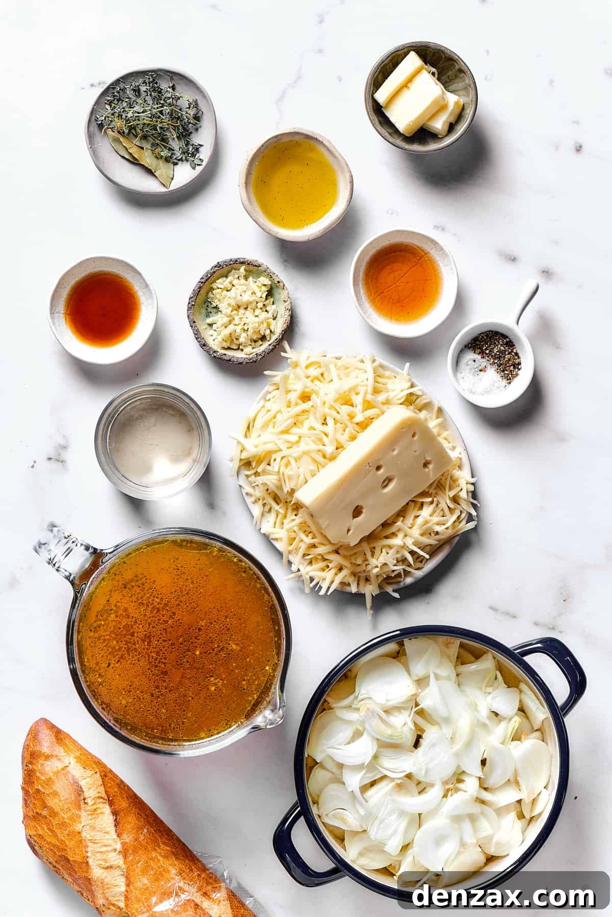 Ingredients for French onion soup arranged on a clean kitchen work surface.