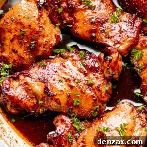cooking boneless chicken thighs in cajun butter sauce, showing the rich color and glistening sauce