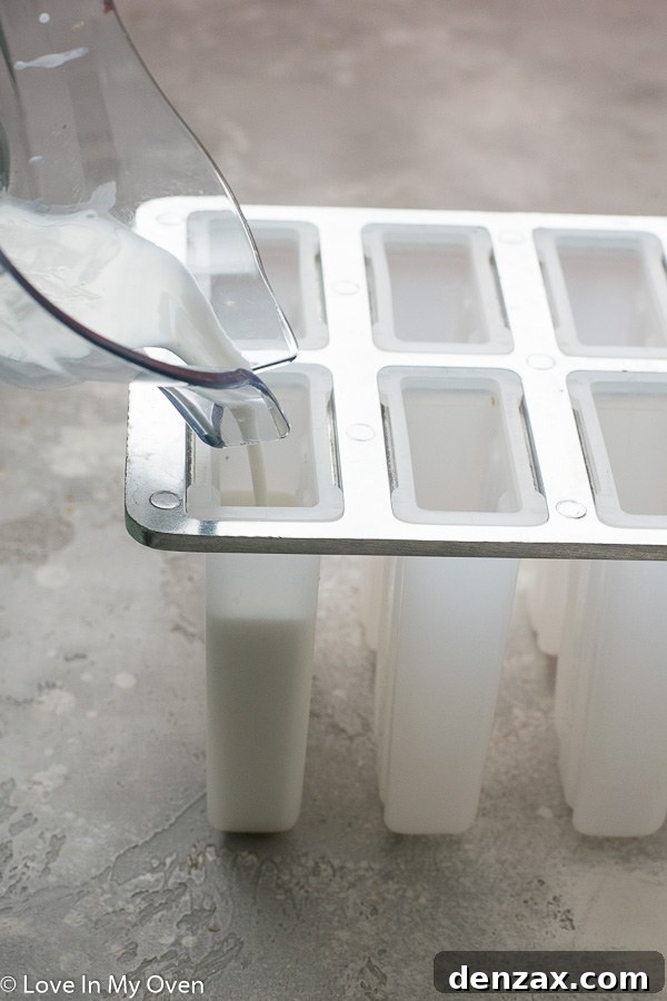 Popsicle molds filled with coconut lime mixture, ready for the freezer.