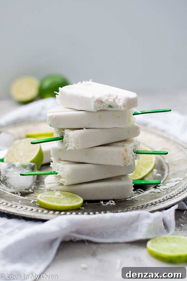 Two coconut lime popsicles leaning against each other, showcasing their vibrant color and refreshing appeal.