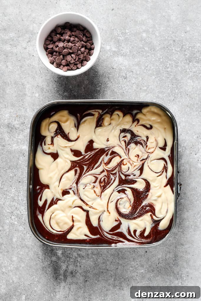 Marbled Chocolate Cheesecake Brownies 11 Unbaked cream cheese brownies featuring a beautifully swirled pattern, topped with chocolate chips.