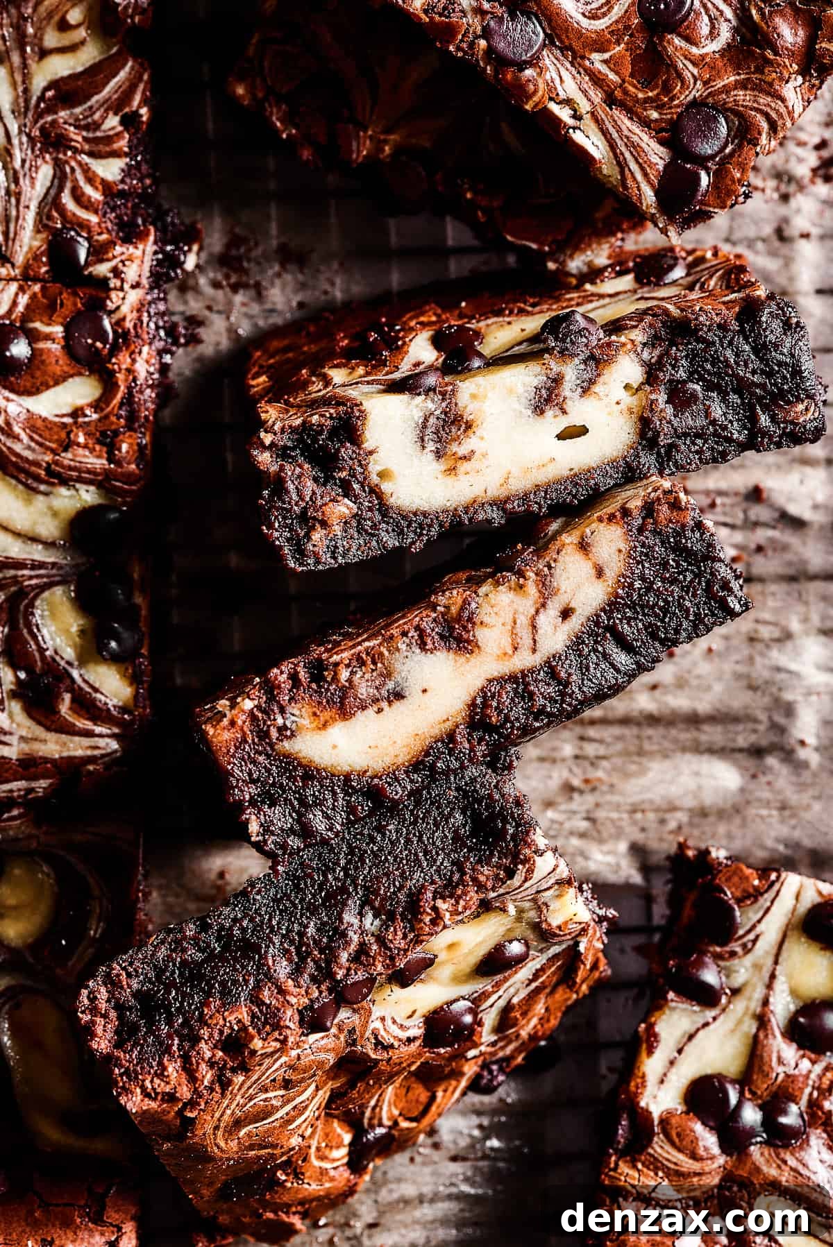 Perfect fudgy brownies get a major upgrade in this Cream Cheese Brownies recipe! An easy dessert loaded with cheesecake and chocolate. Side view of a generous square of cream cheese brownie, revealing the rich layers and tempting swirl.