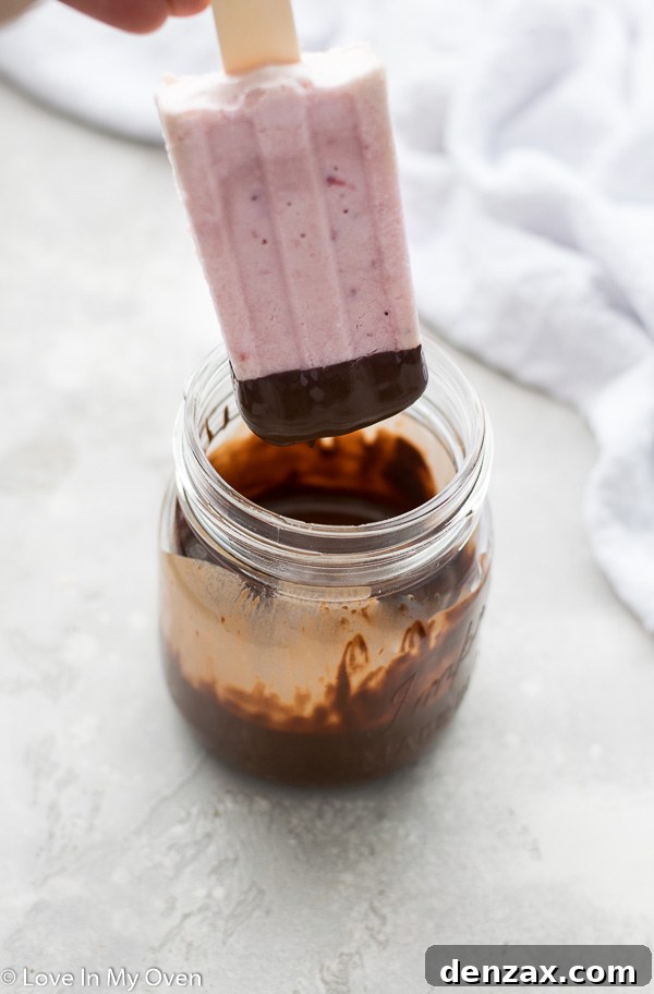 dipping ice cream bar into melted chocolate