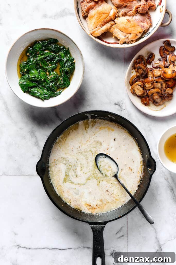 Comforting Creamy Chicken Gnocchi 5 A creamy, bubbling sauce simmering in a skillet, with plates of cooked spinach, chicken, and mushrooms ready for assembly.