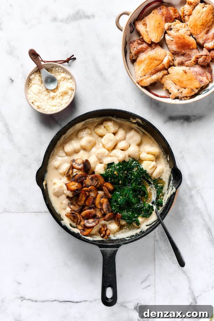 Comforting Creamy Chicken Gnocchi 7 The final step: combining the cooked mushrooms and spinach into the skillet with the creamy gnocchi and chicken.