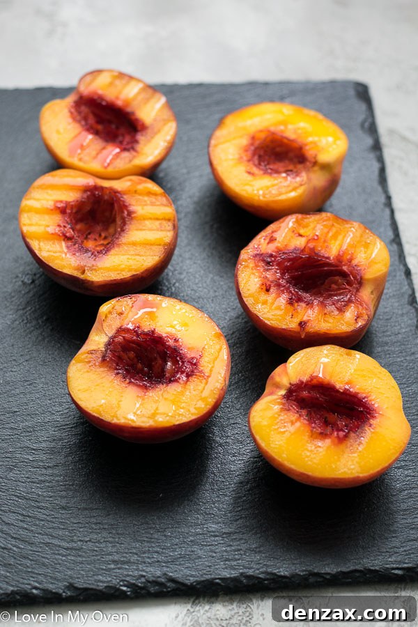 Halved peaches grilling on an outdoor barbecue