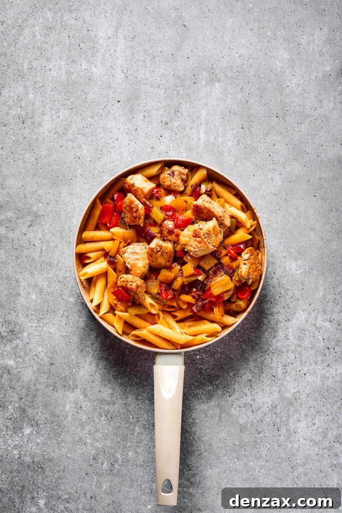 This Chicken Fajita Pasta, prepared with tender veggies and juicy chicken, makes the perfect dinner for family night or a casual get-together with friends. Chicken fajita pasta in a skillet.