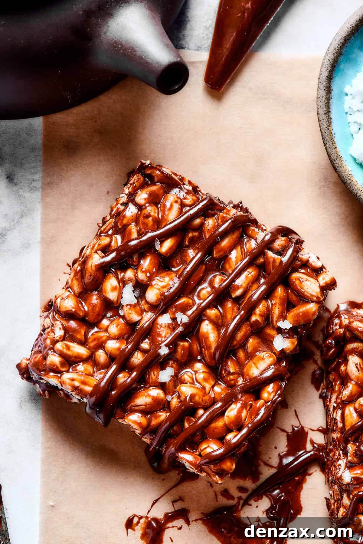 A perfectly formed square of chocolate rice and marshmallow treat, featuring a glossy chocolate drizzle on top, highlighting its rich textures.