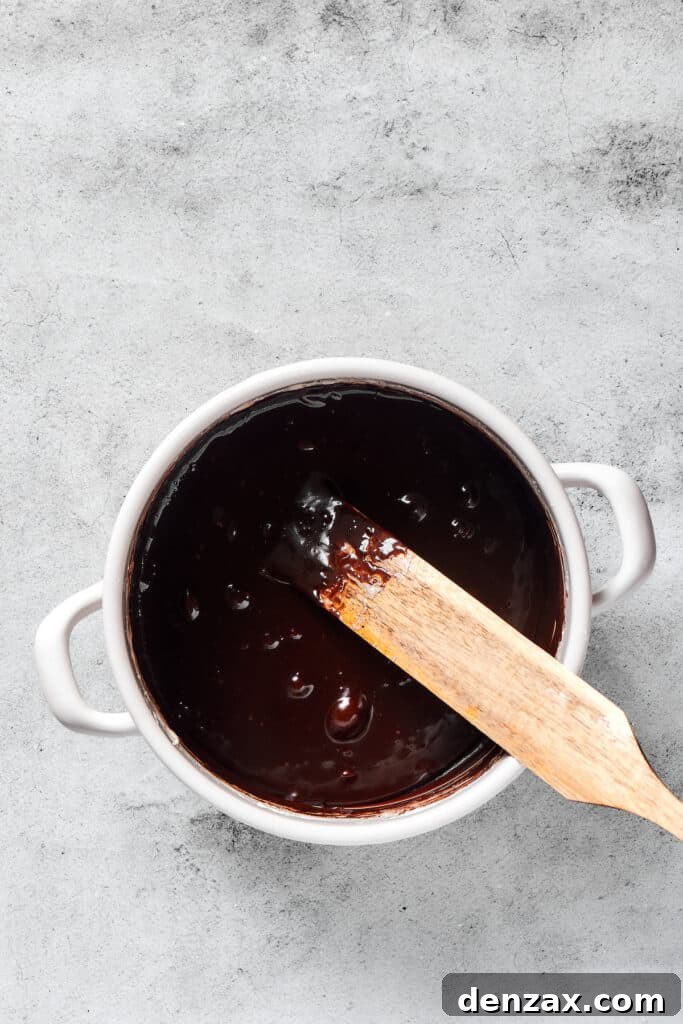 A rich, glossy chocolate marshmallow mixture, perfectly melted and combined, ready for the crispy cereal.