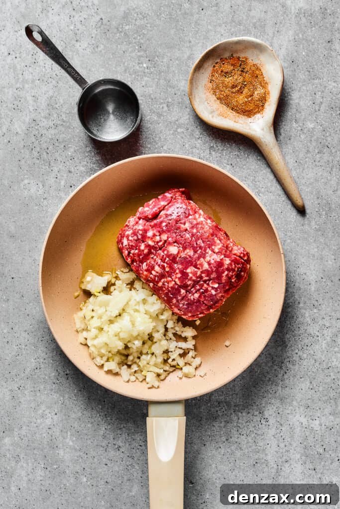 Cooking onion and ground beef in a skillet.