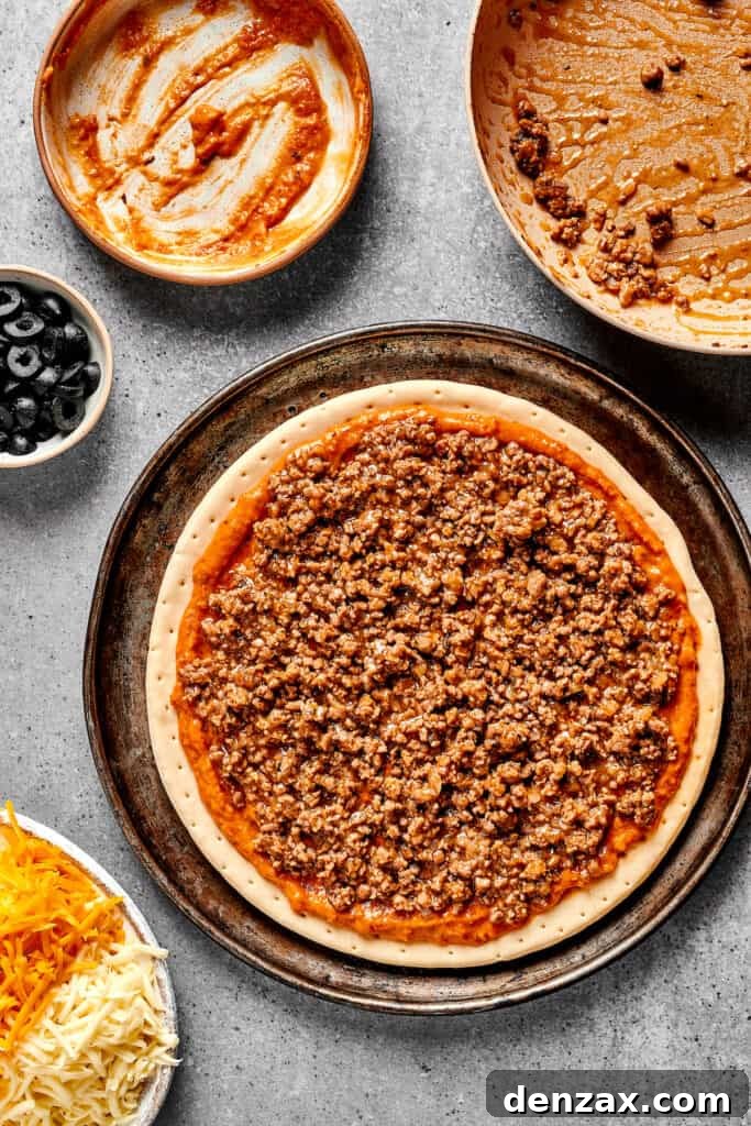 Beans, salsa, and meat on a pizza crust.