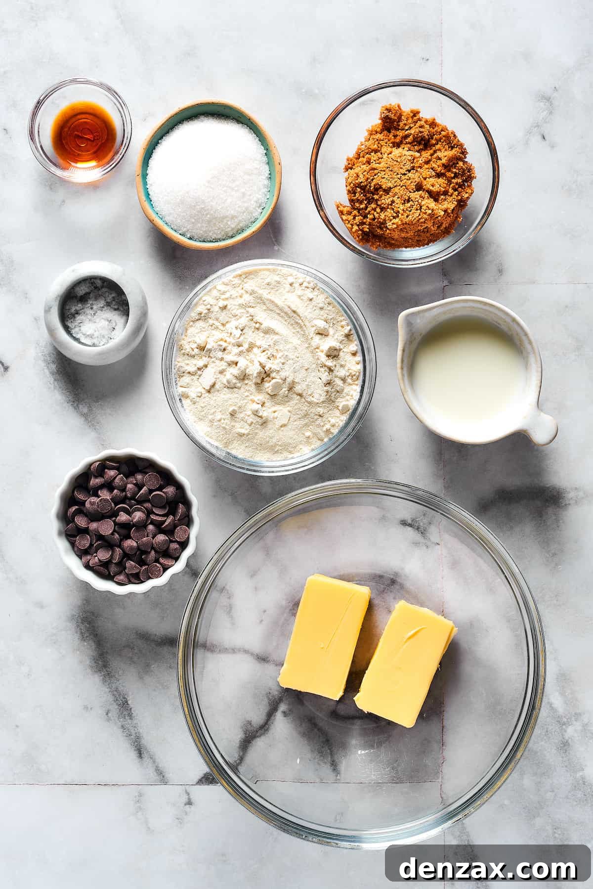 From top: Vanilla, granulated sugar, brown sugar, salt, flour, milk, chocolate chips, butter, neatly arranged ingredients for edible cookie dough.