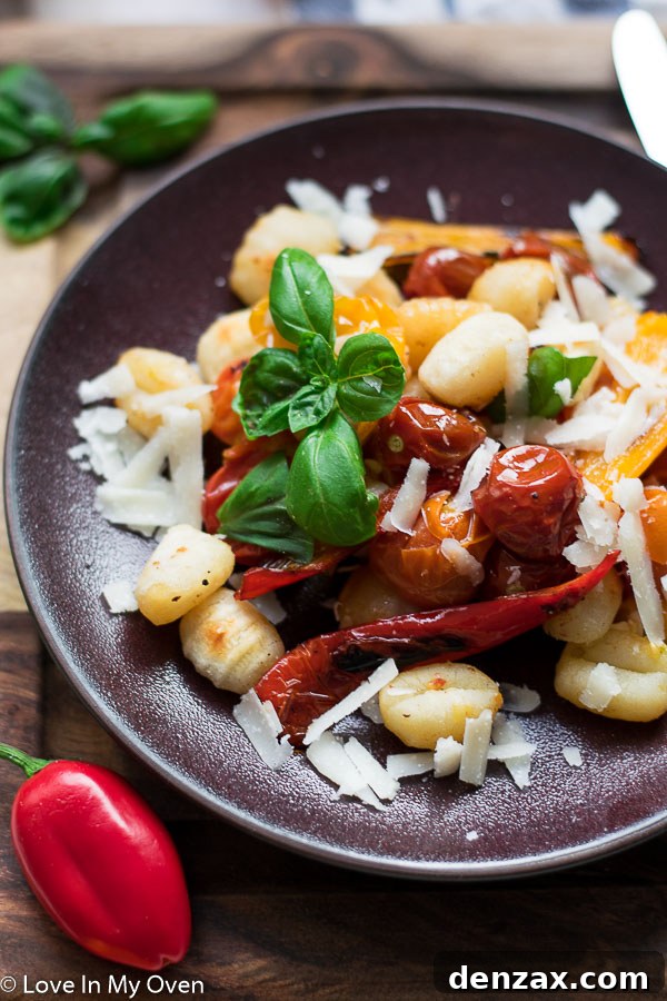Close-up of golden crispy gnocchi on a sheet pan with roasted vegetables