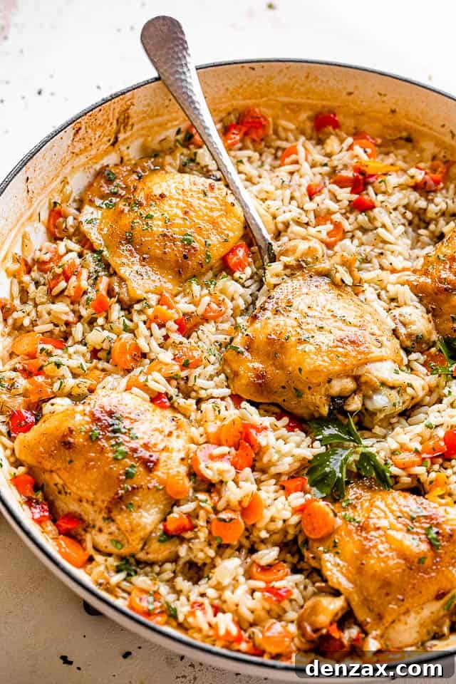 scooping out chicken thighs set on a bed of rice inside a white skillet