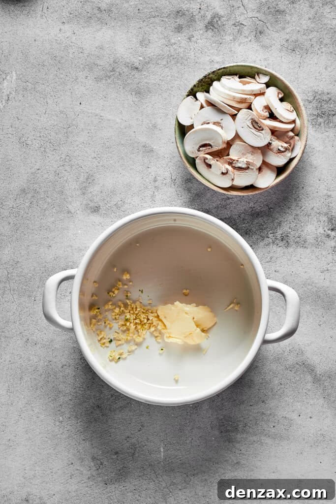 Melted butter and minced garlic simmering in a soup pot, preparing for the sauce base.