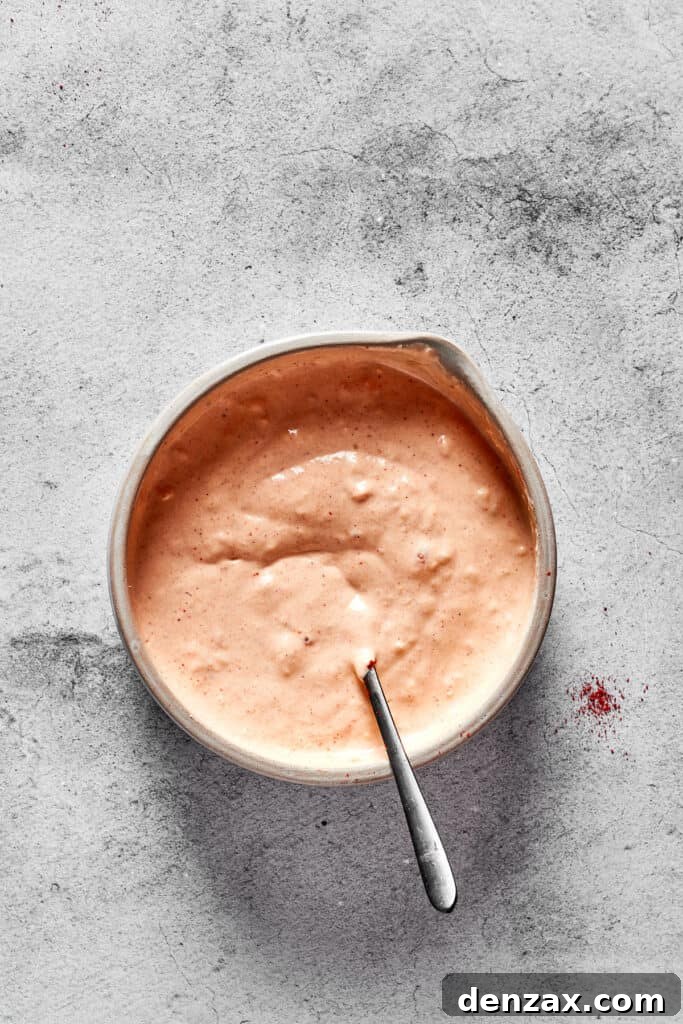 The vibrant Russian salad dressing is showcased in a mixing bowl, perfectly blended to a smooth and creamy consistency.