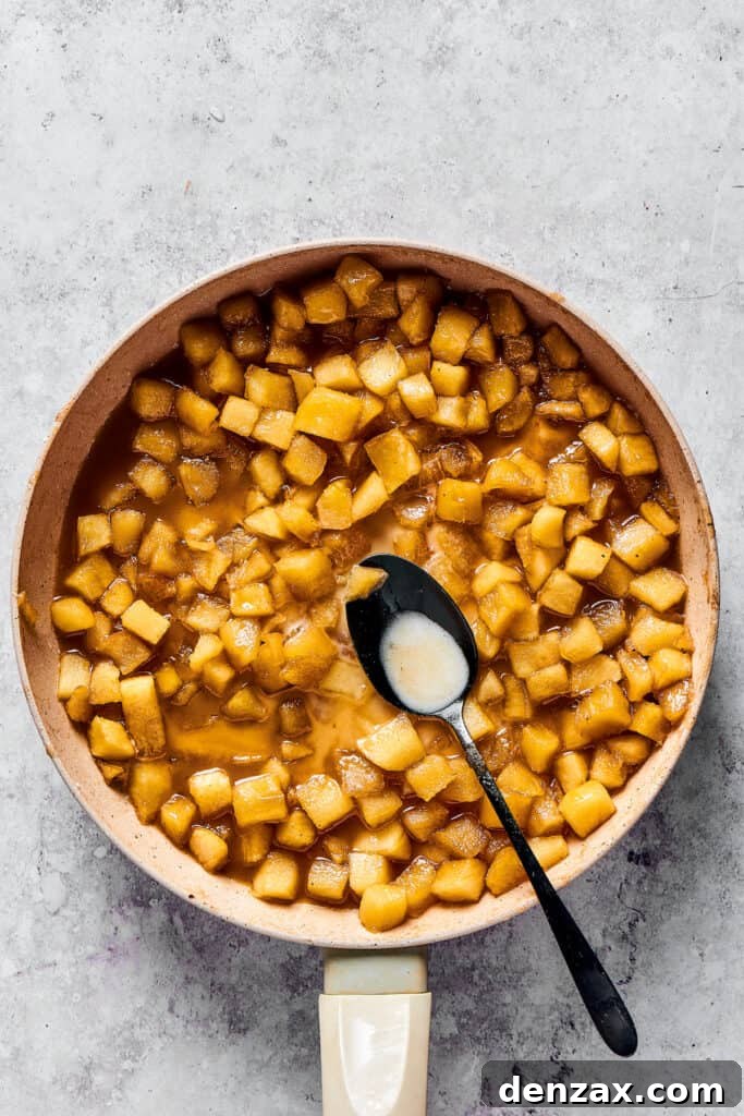 A small bowl containing a smooth, opaque mixture of cornstarch and water, ready to be added to the apple filling.