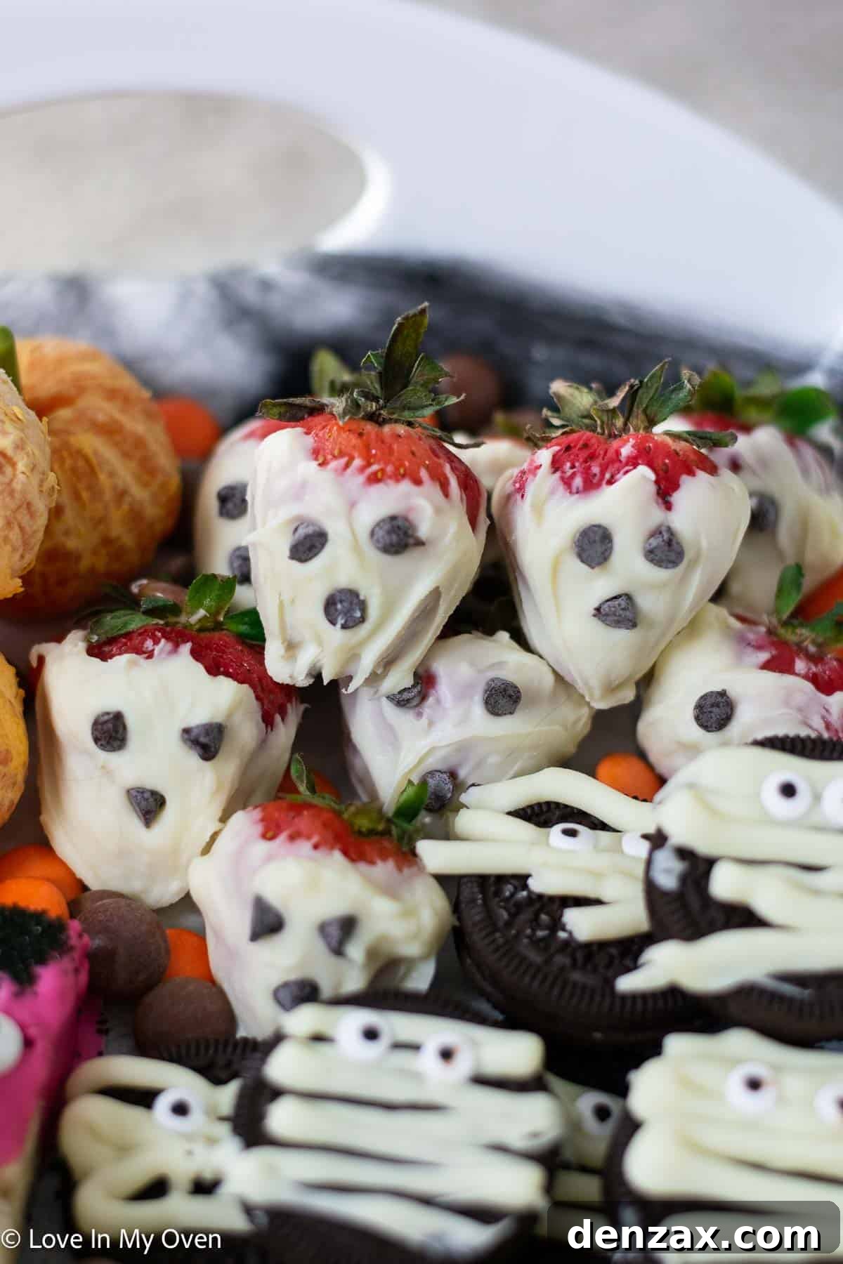 Spooky Sweet Creations for Kids 11 White chocolate-covered strawberry ghosts with mini chocolate chip eyes on a Halloween platter.