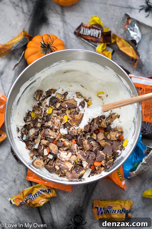 Folding chopped Halloween candy into the no-churn ice cream base
