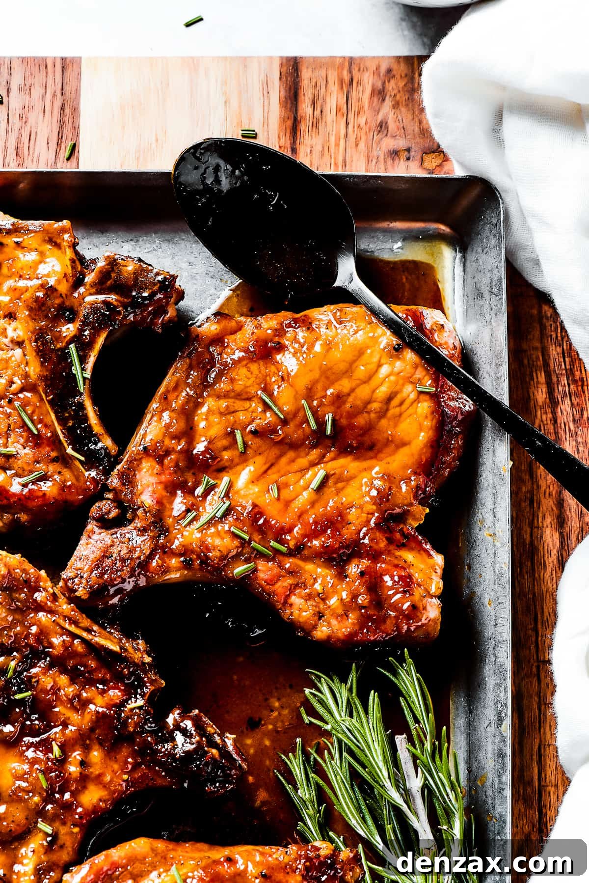 Gorgeous Brown Sugar Pork Chops may look fancy, but they are actually so simple to make! Savory, pan-fried chops with brown sugar glaze. Spooning sauce over pork chops.