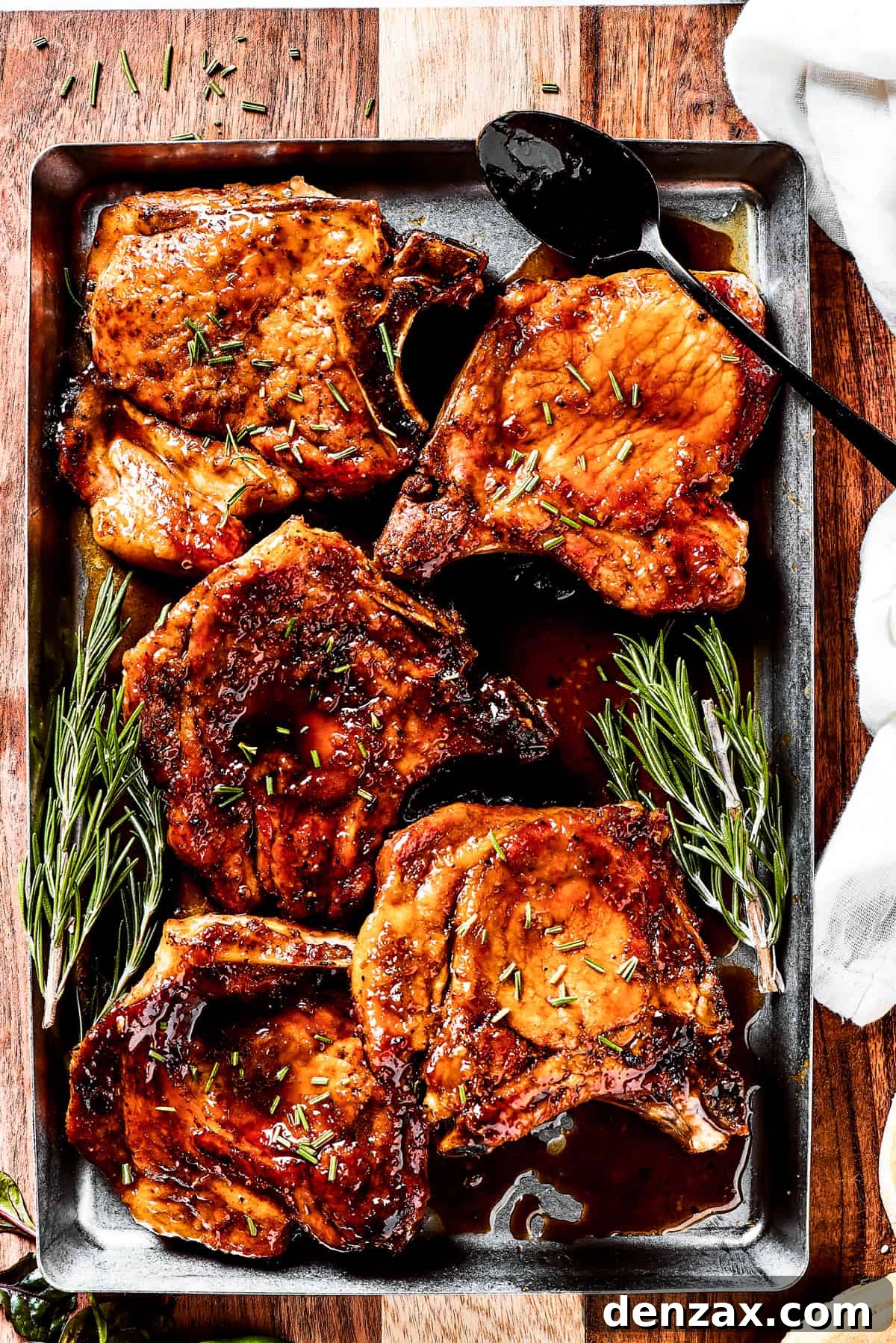 Gorgeous Brown Sugar Pork Chops may look fancy, but they are actually so simple to make! Savory, pan-fried chops with brown sugar glaze. A tray of brown sugar pork chops with fresh herbs.