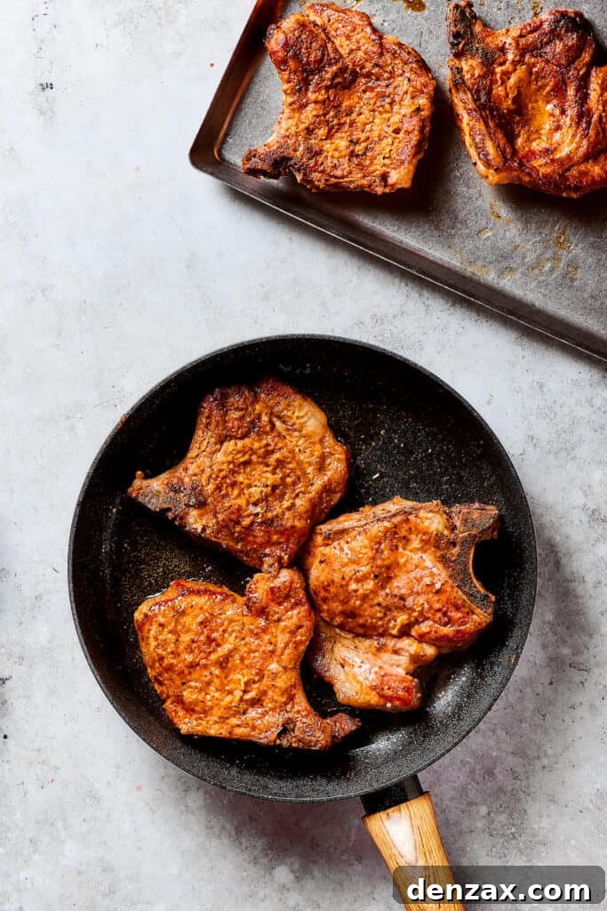 Gorgeous Brown Sugar Pork Chops may look fancy, but they are actually so simple to make! Savory, pan-fried chops with brown sugar glaze. Browned pork chops in a skillet and other set aside on a tray.