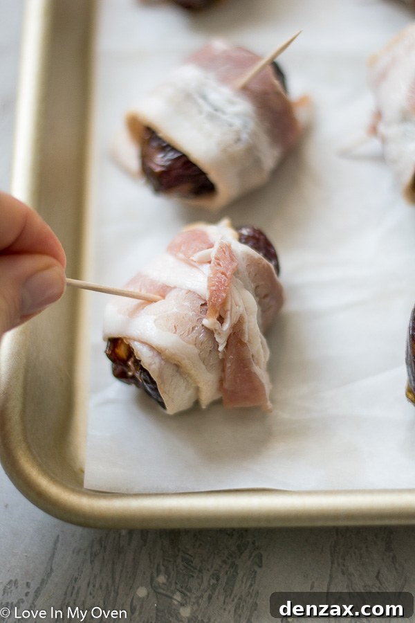 Goat cheese being spooned into the pit cavity of a Medjool date.
