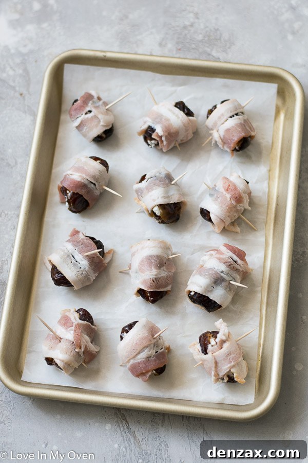 Bacon strips being wrapped around a goat cheese stuffed date and secured with a toothpick.