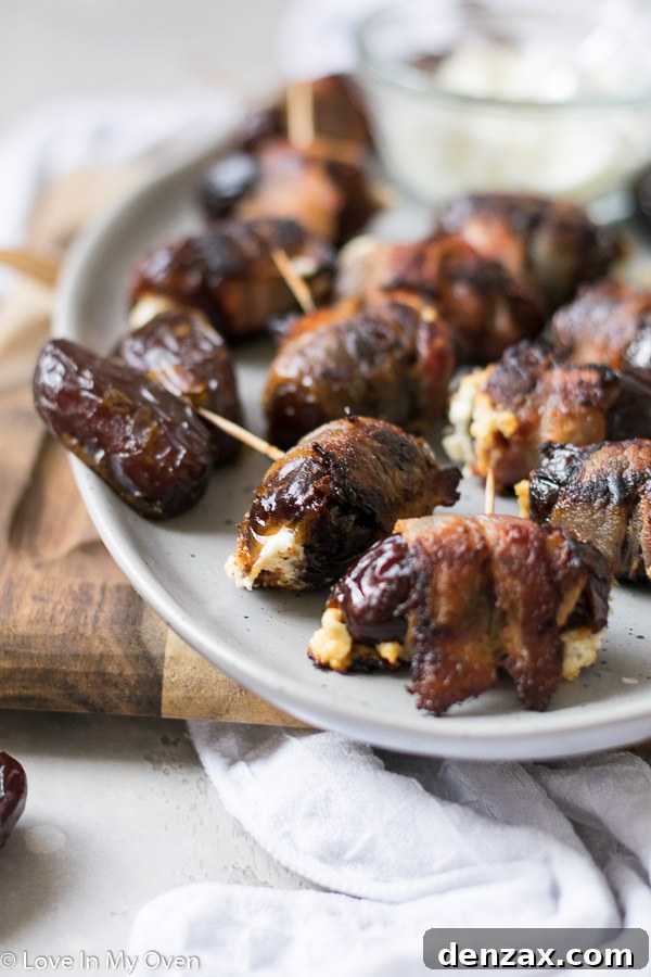 Platter of freshly baked bacon-wrapped stuffed dates, golden and crispy, ready to be served.