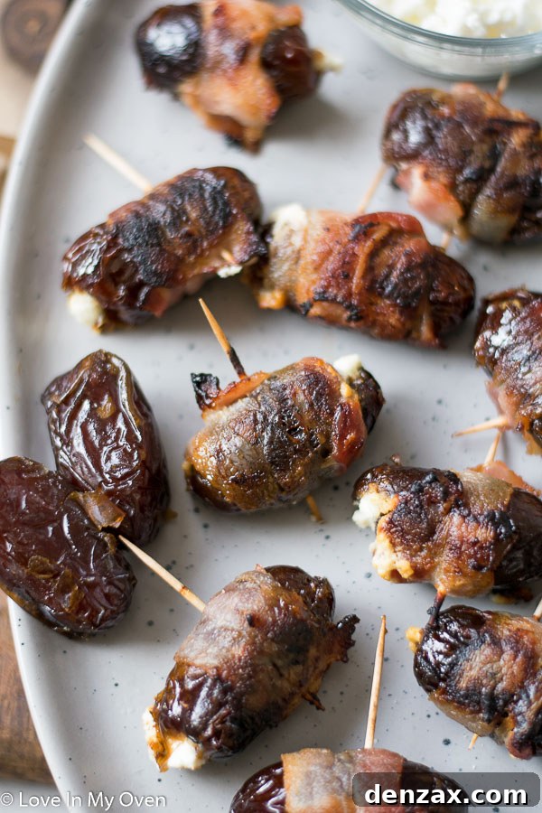 Close-up of a single bacon-wrapped stuffed date, showcasing the texture of the date, goat cheese, and crispy bacon.