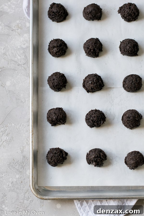 Hand-rolled Oreo truffle balls resting on a parchment-lined baking sheet