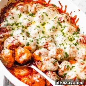 white baking dish filled with baked meatballs covered in marinara sauce and melted cheese